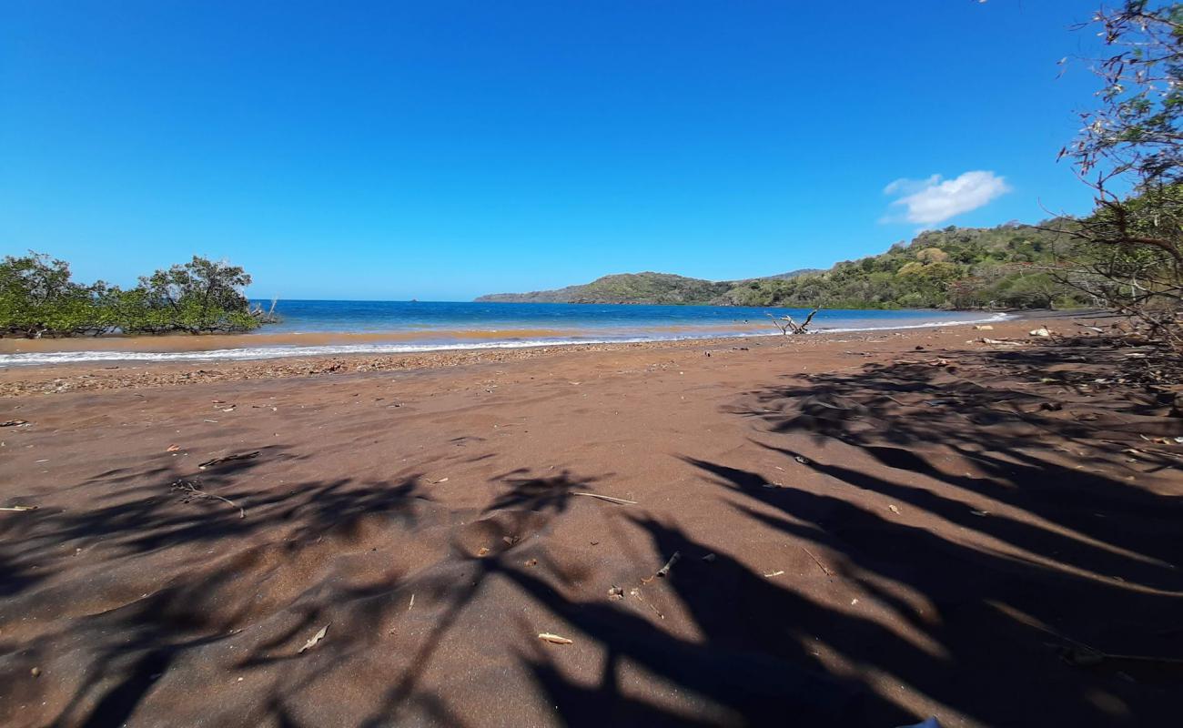 Фото Iloni Beach с темный песок поверхностью