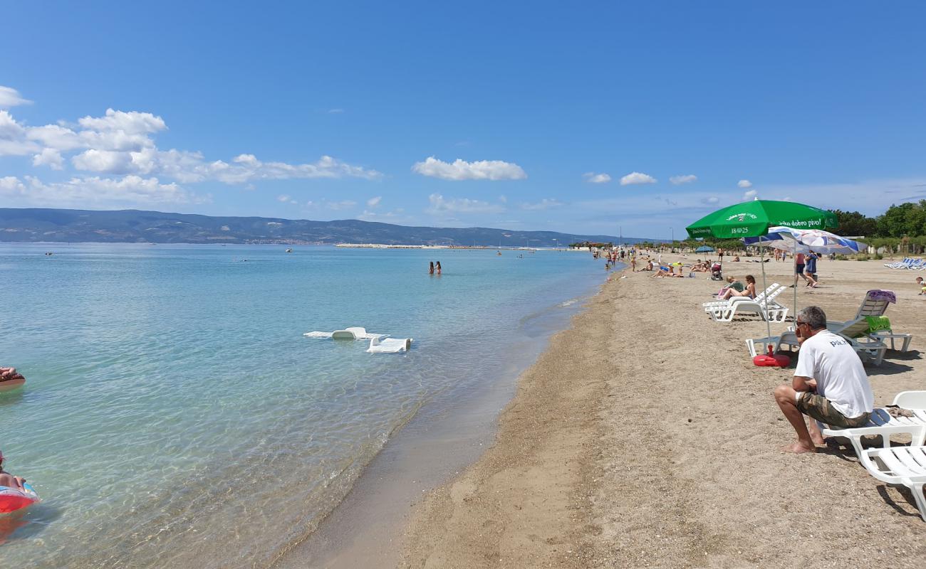 Фото Omis beach с темный песок поверхностью