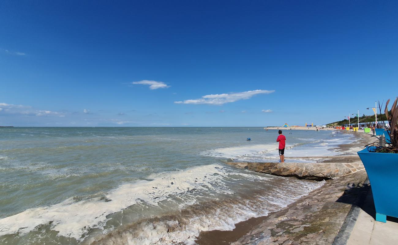 Фото Petit-Fort-Philippe Beach с темный песок поверхностью