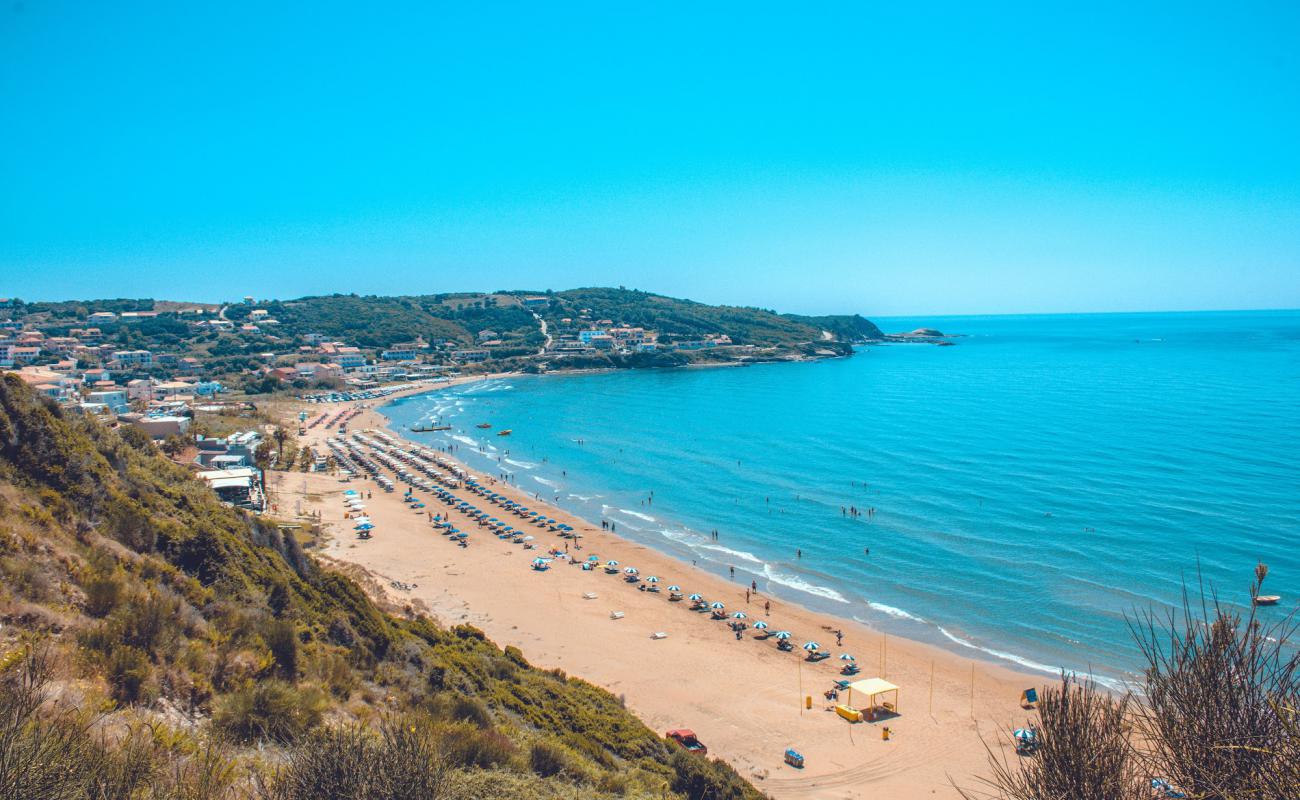 Фото Agios Stefanos beach с темный чистый песок поверхностью