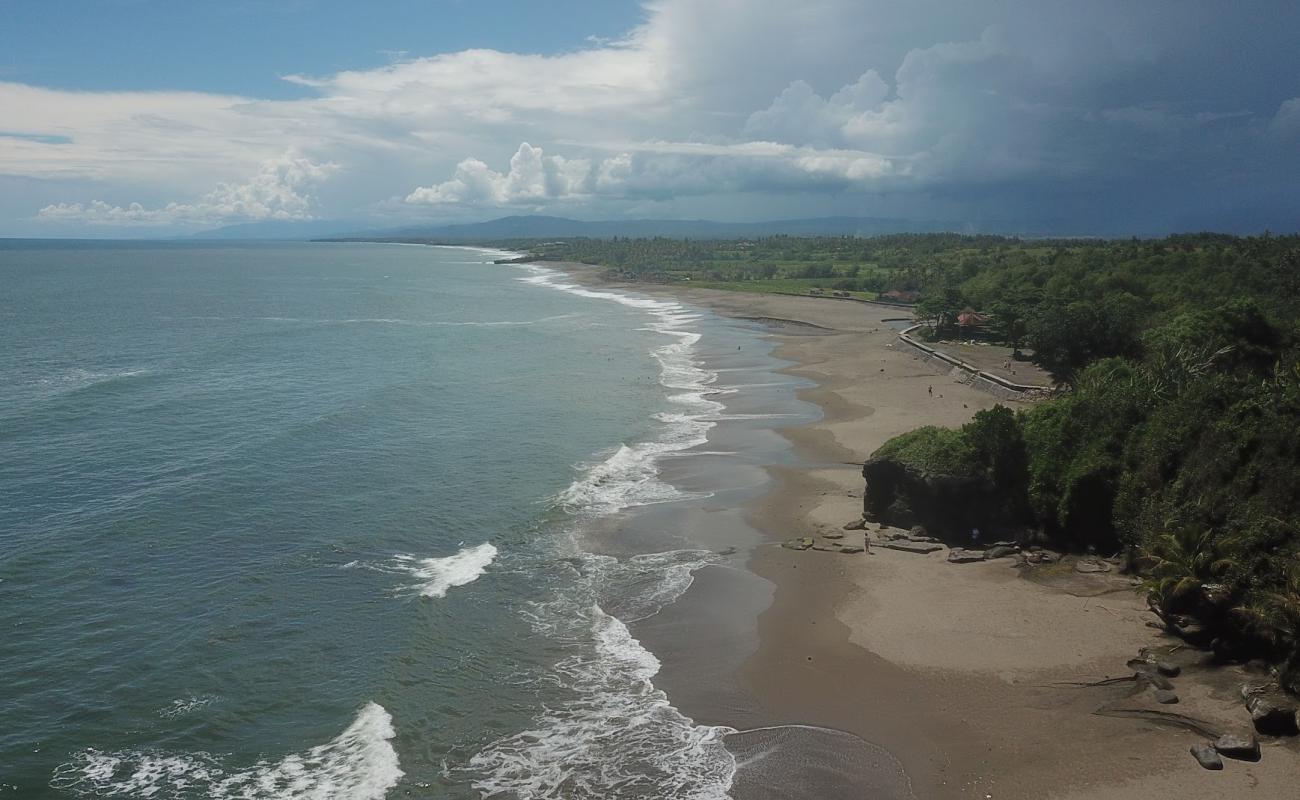 Фото Kedungu Beach с серый чистый песок поверхностью