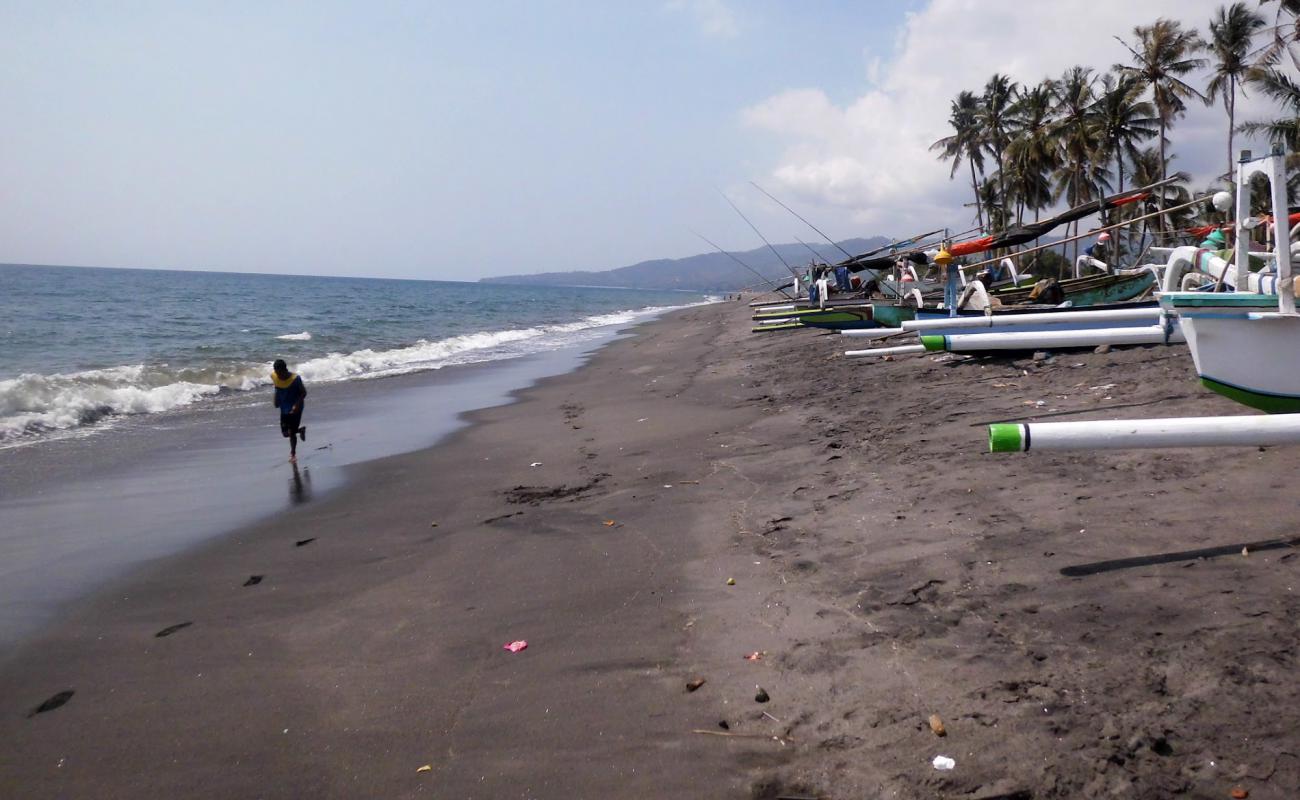 Фото Meninting Beach с темный песок поверхностью