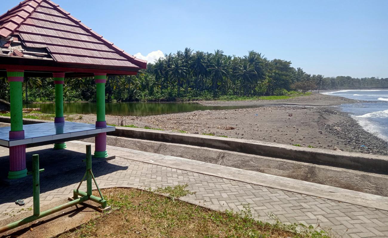 Фото Dharmawangi Beach с песок с галькой поверхностью