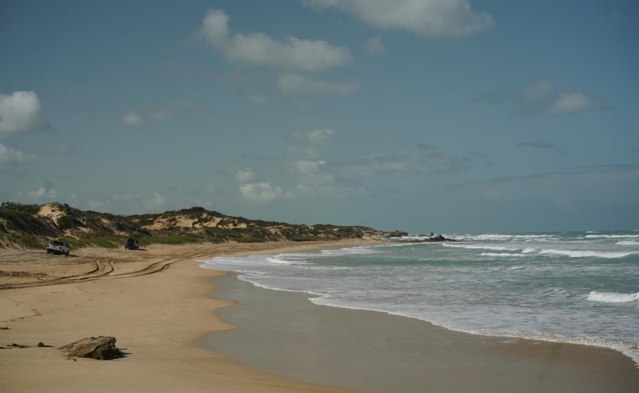 Фото Back Beach с светлый песок поверхностью