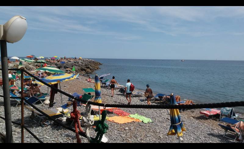 Фото Landini beach с темная чистая галька поверхностью