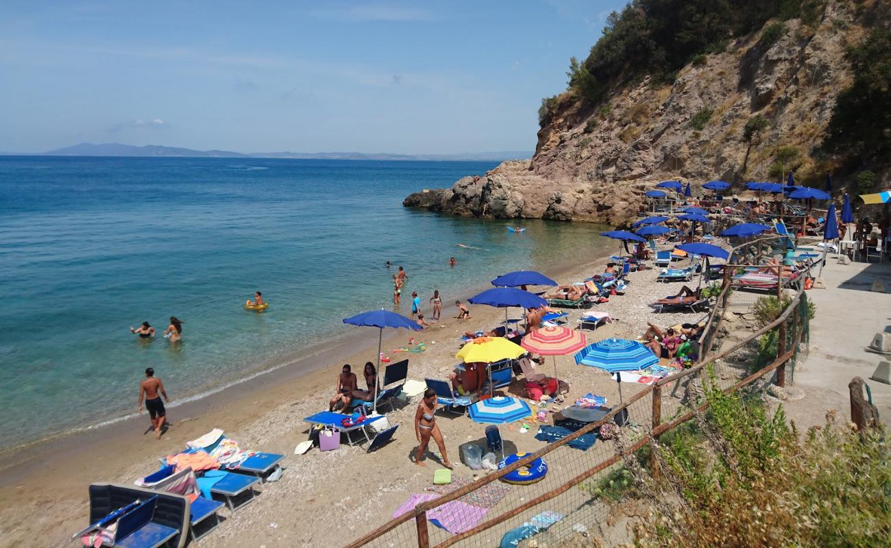 Фото Spiaggia La Cantoniera с темная чистая галька поверхностью