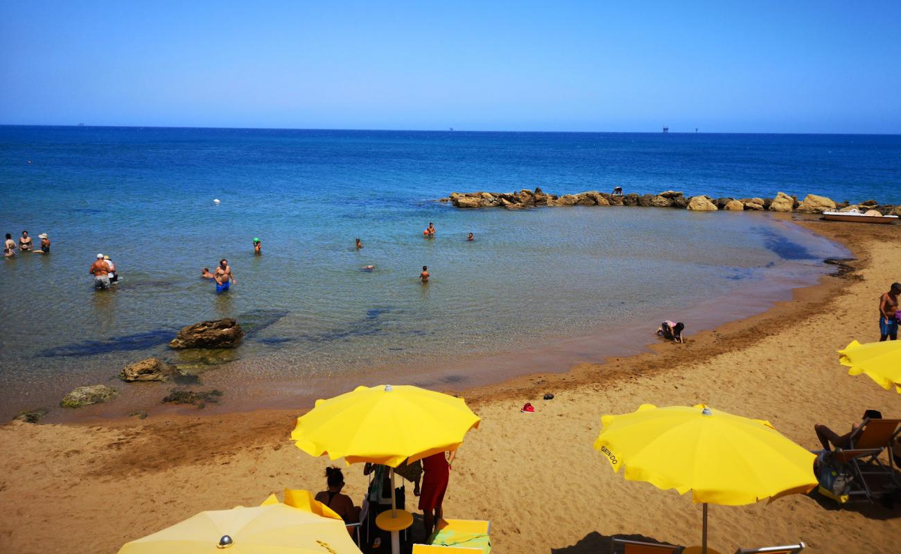 Фото Spiaggia di Via Makalla с темный песок поверхностью