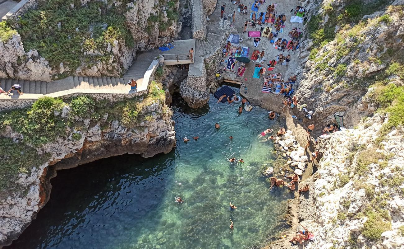 Фото Baia del Ciolo с песок с камнями поверхностью