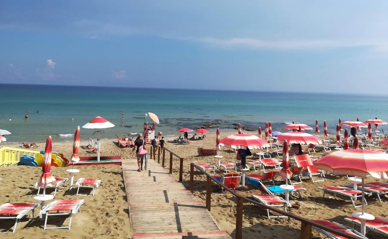 Фото Spiaggia Via di Torre Resta с золотистый песок поверхностью