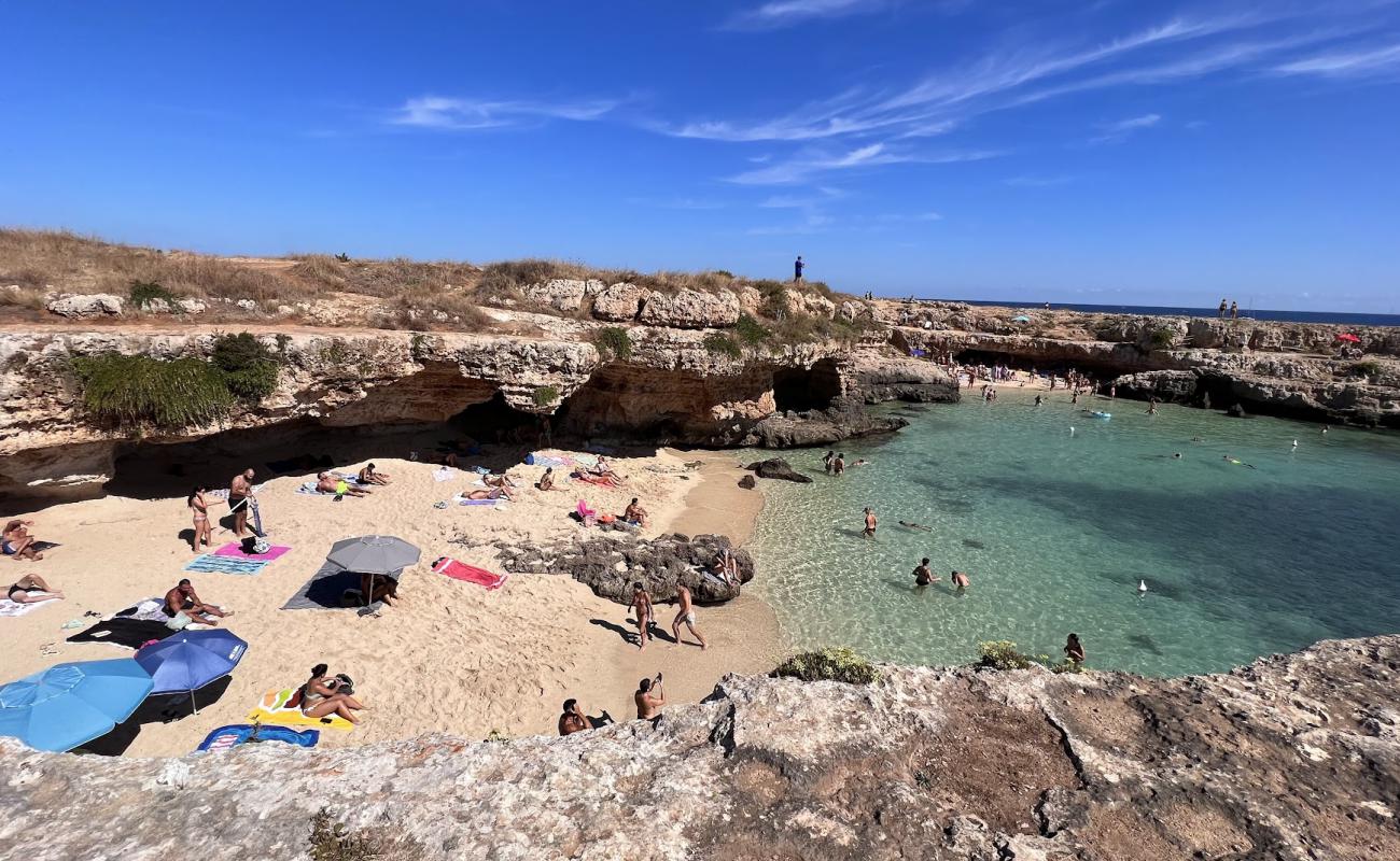 Фото Grotta della Cala Tre Buchi с светлый песок поверхностью