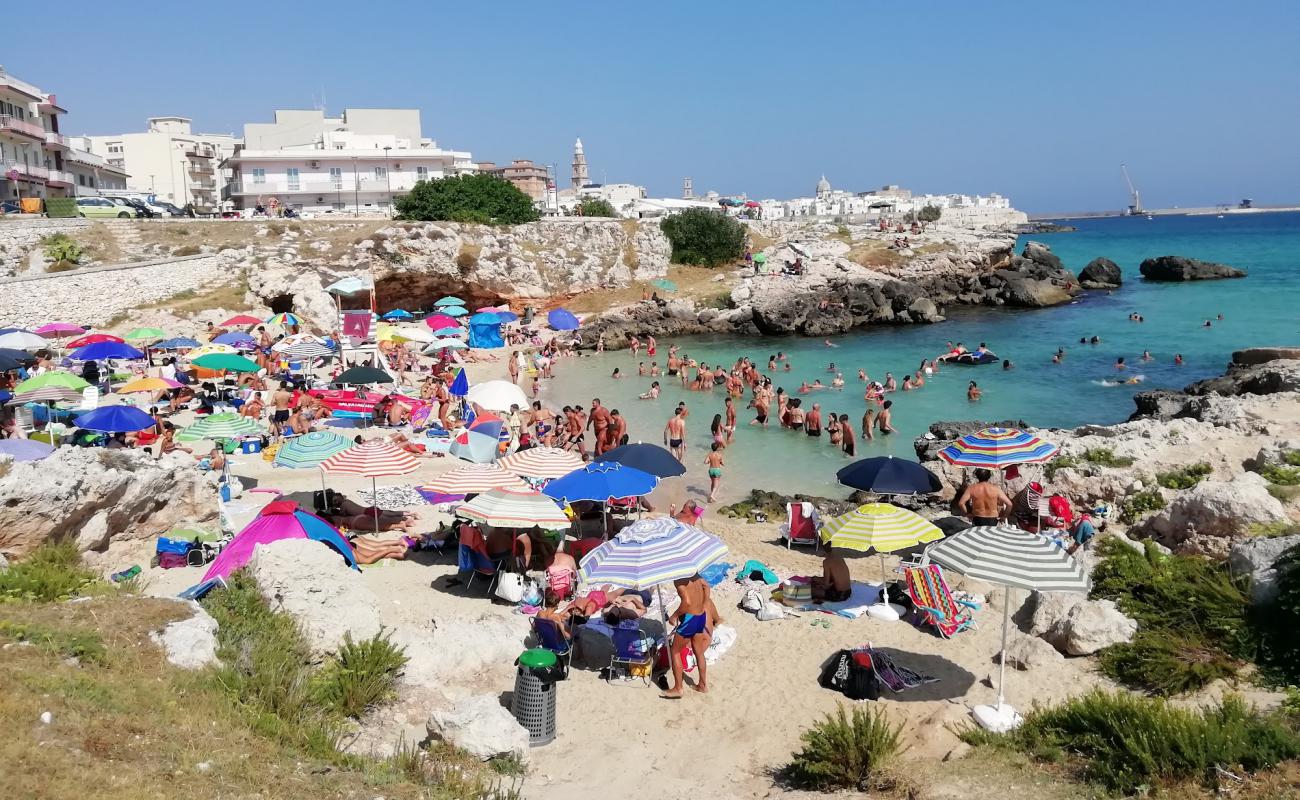 Фото Spiaggia di Cala Porto Rosso с светлый песок поверхностью