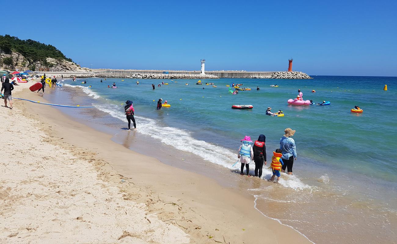 Фото Baekdo Beach с светлый песок поверхностью