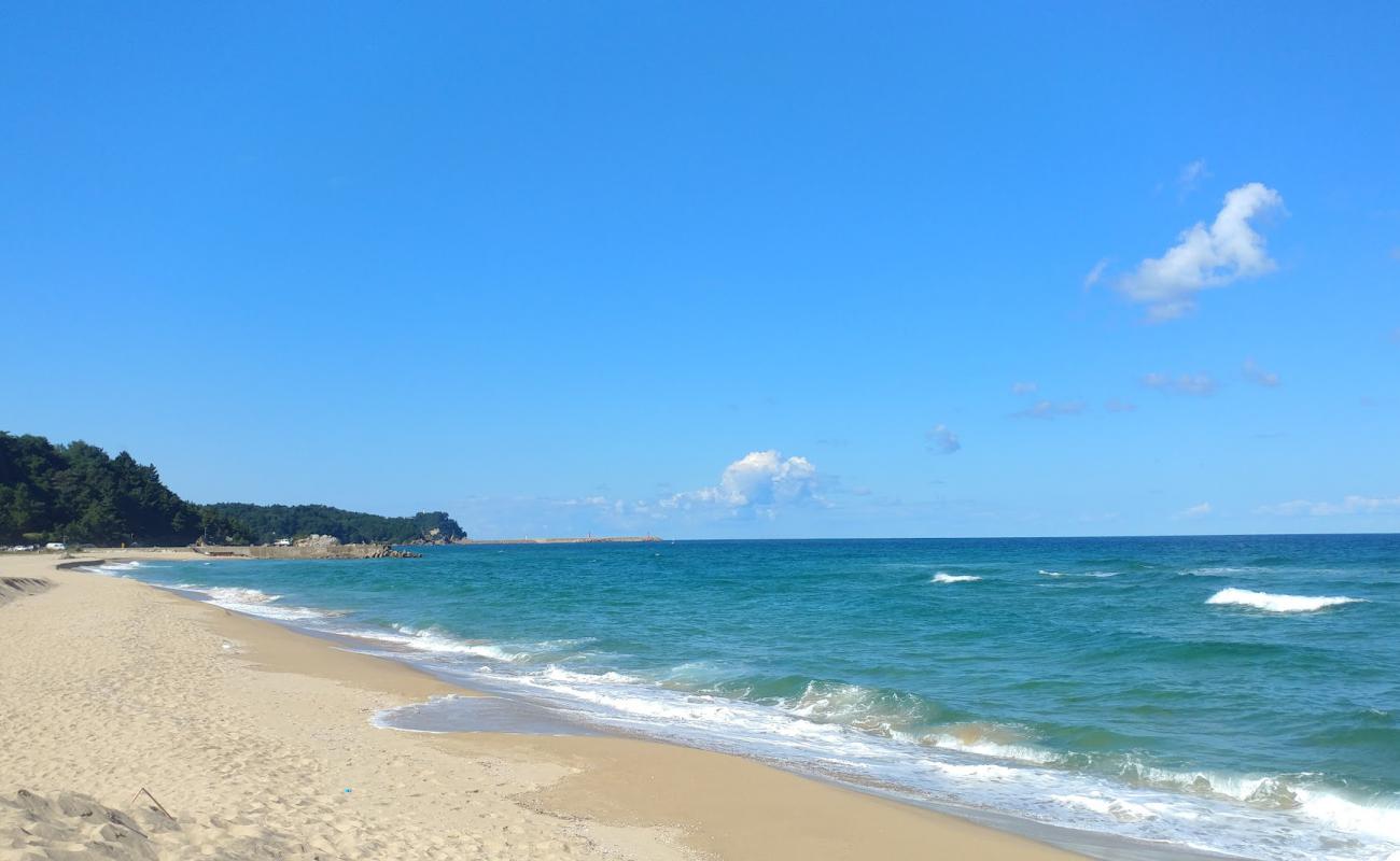 Фото Dongho Beach с светлый песок поверхностью