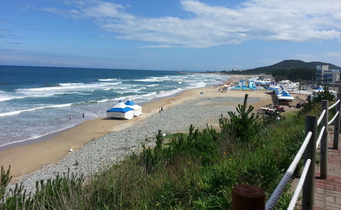 Фото Hwajin Beach с светлый песок поверхностью