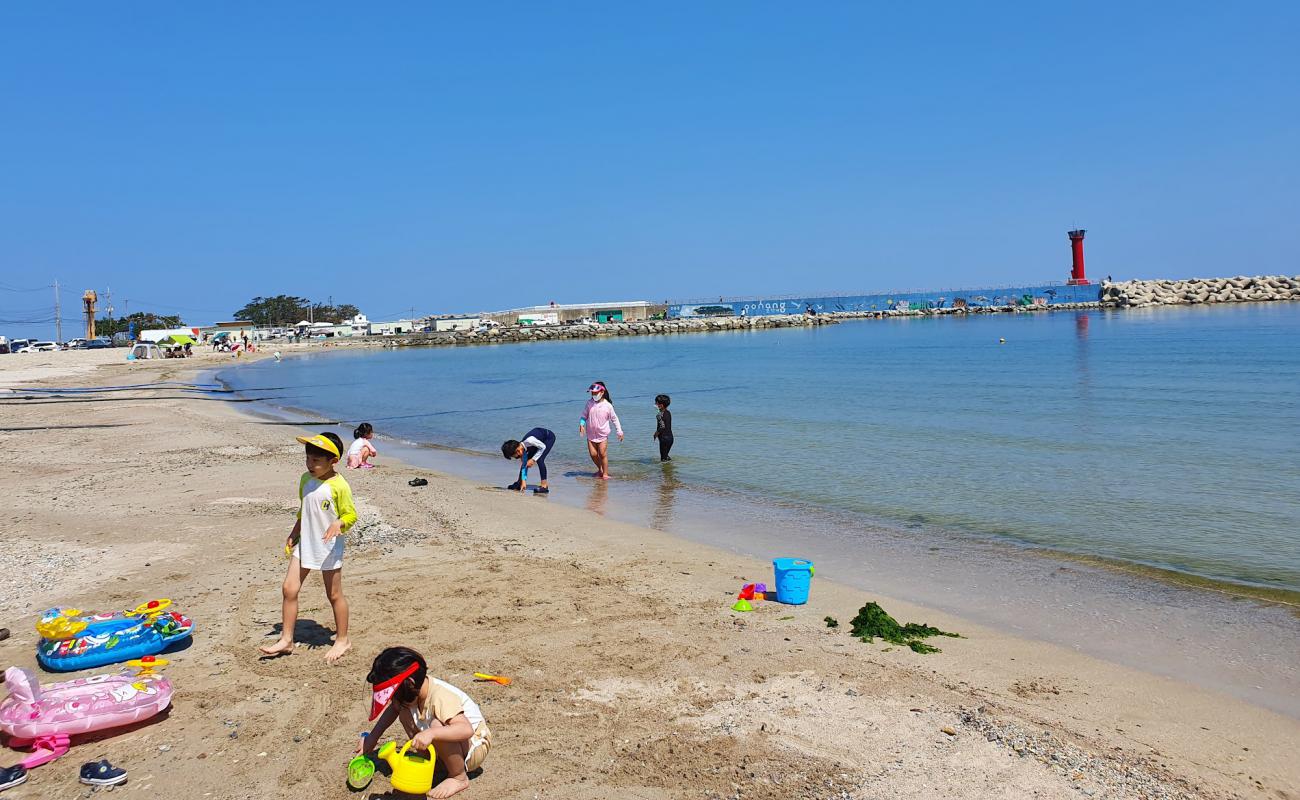 Фото Samjeong Beach с светлый песок поверхностью