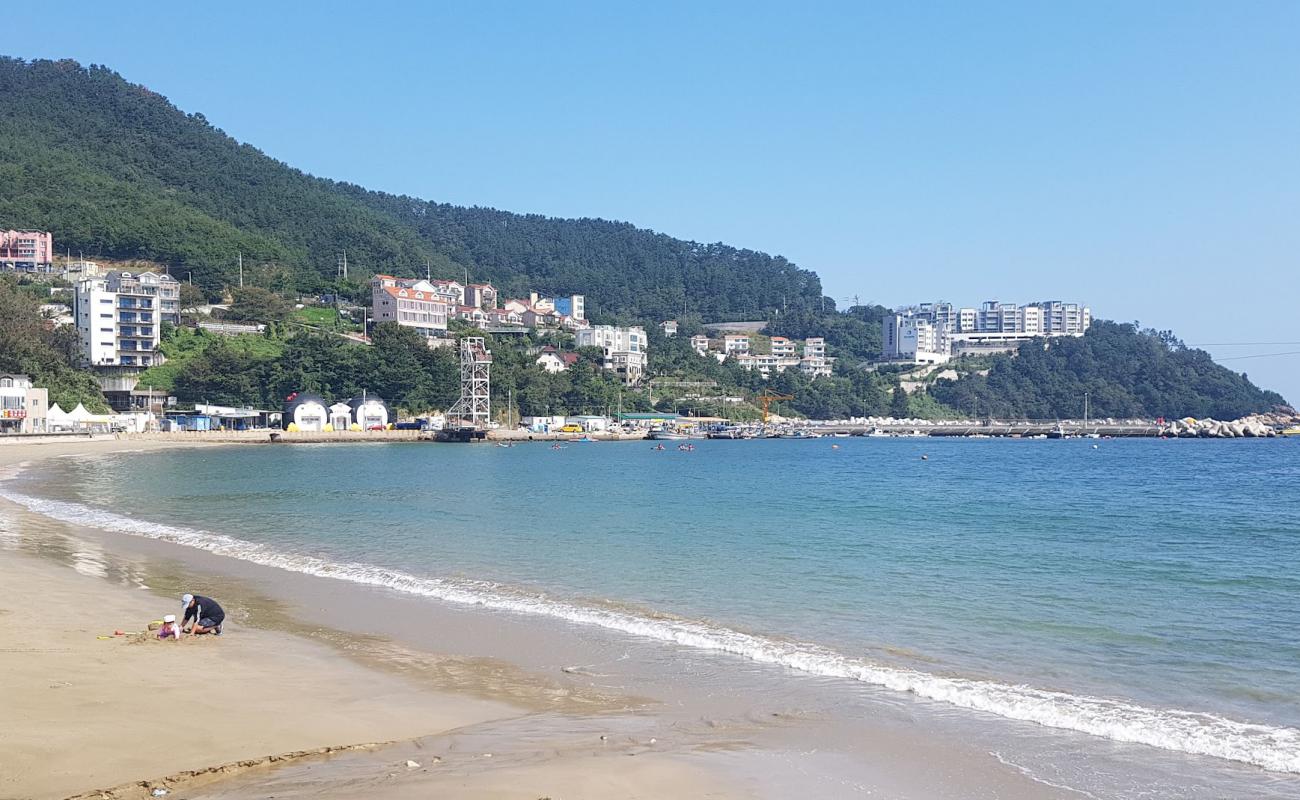 Фото Deokpo Beach с светлый песок поверхностью