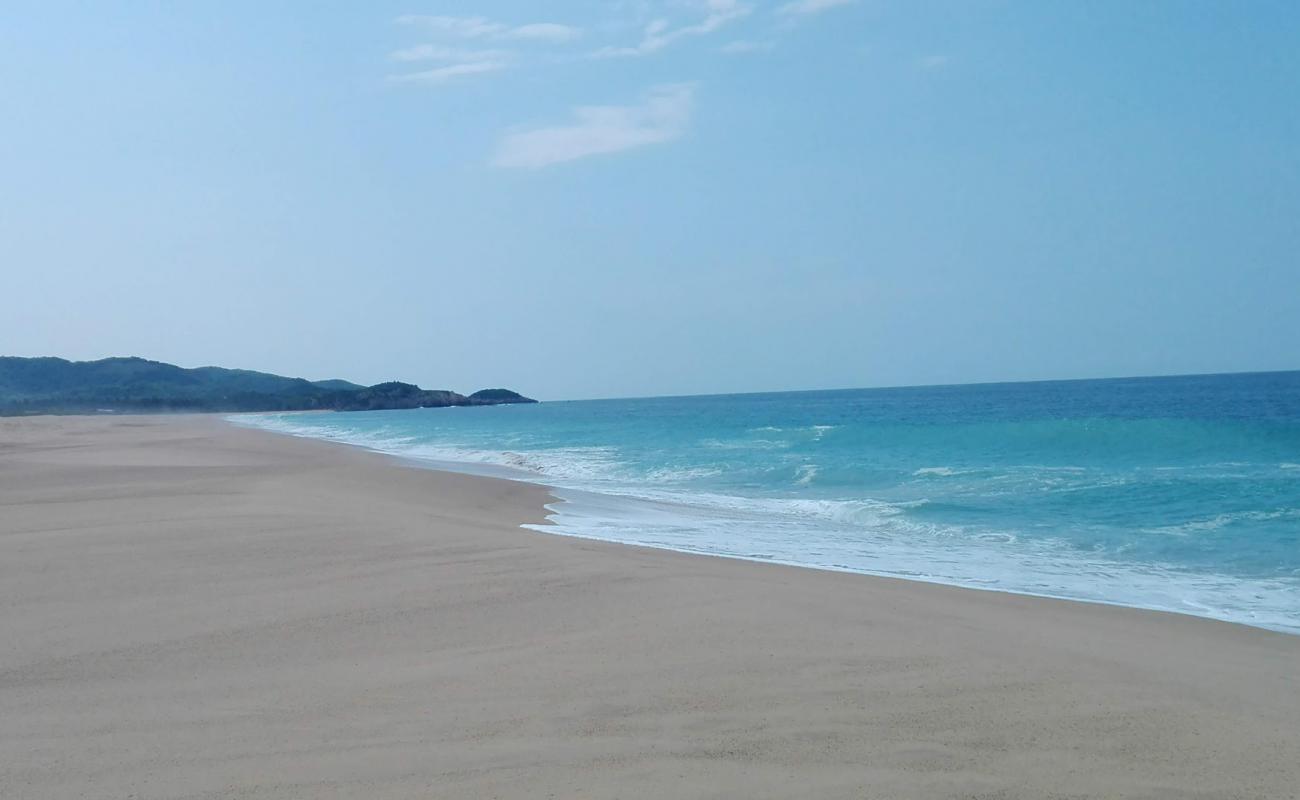 Фото Colola Beach с светлый песок поверхностью