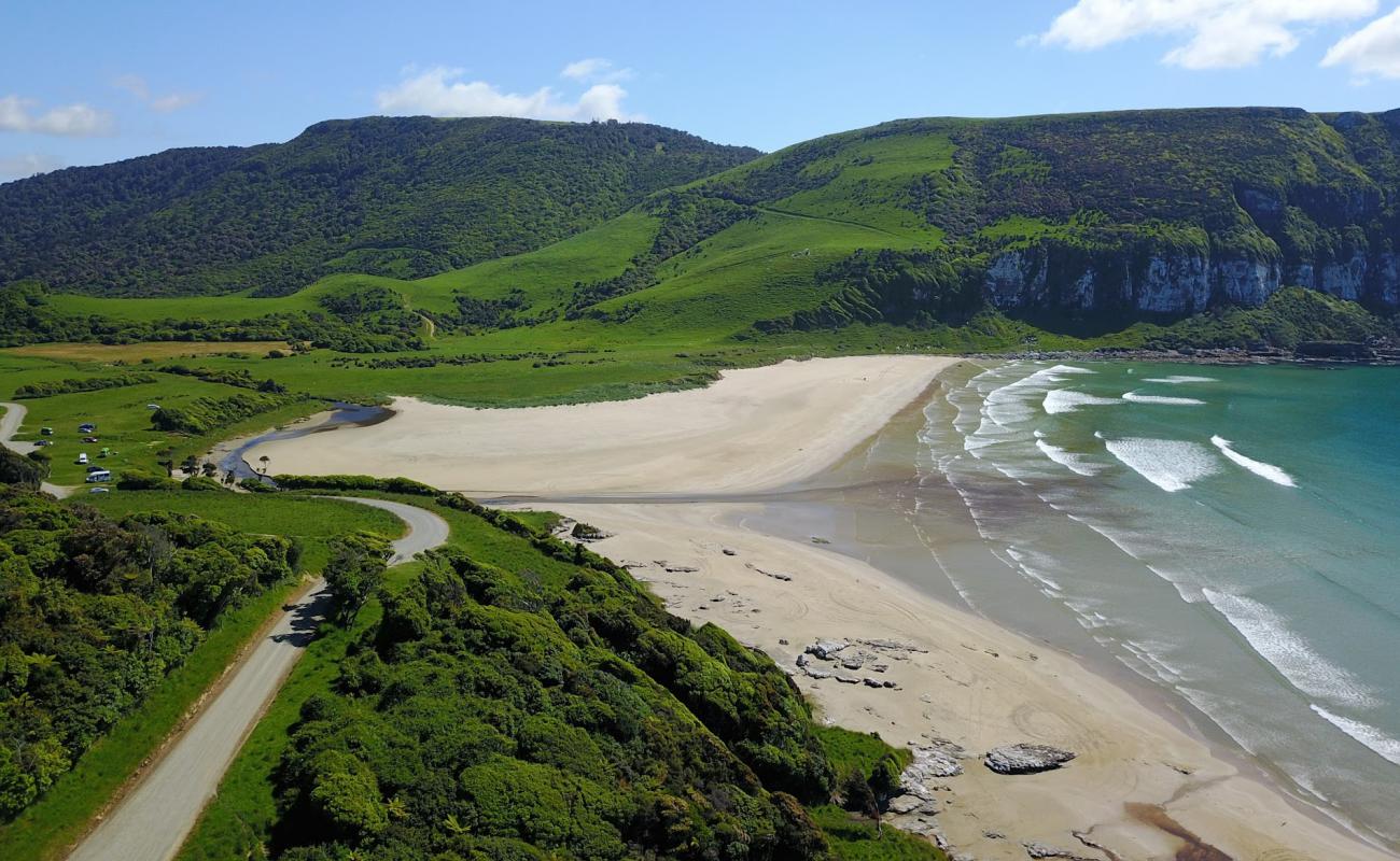 Фото Purakaunui Bay Beach с светлый песок поверхностью