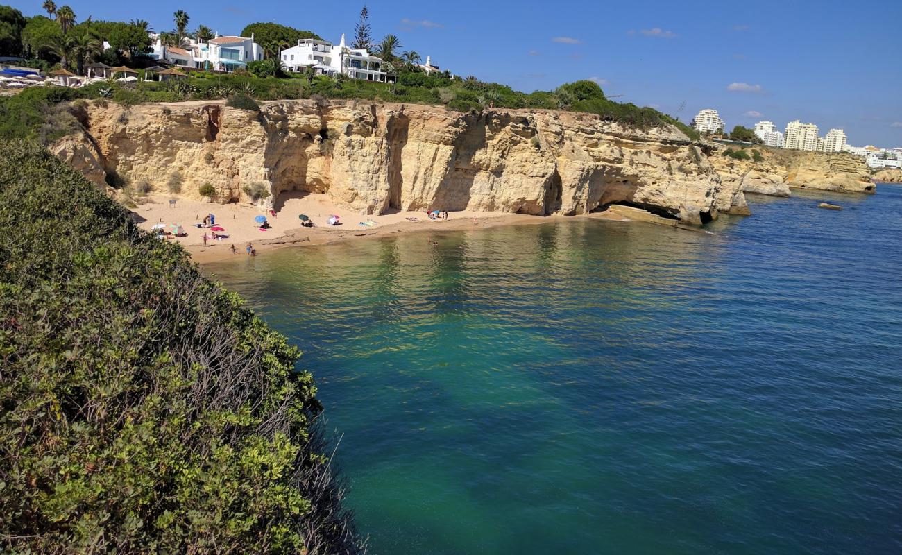 Фото Praia dos Tremocos с темный чистый песок поверхностью