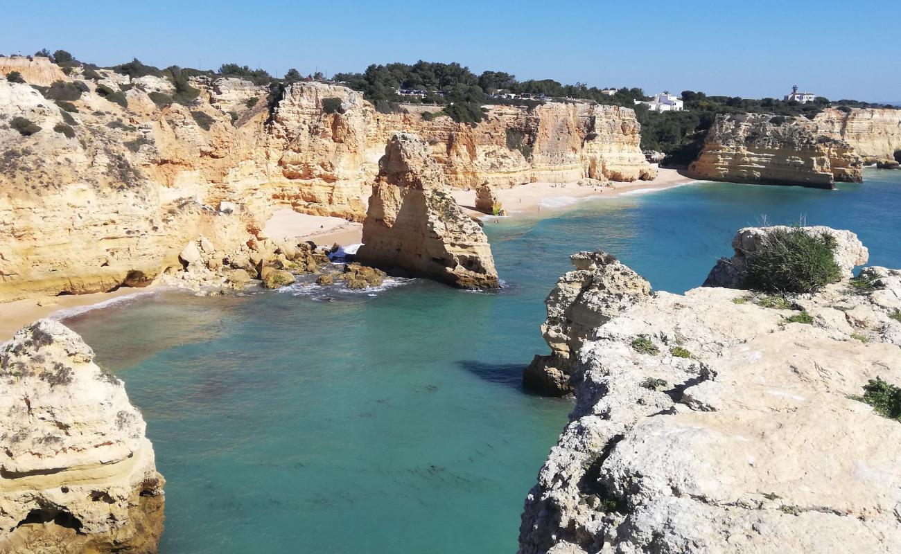 Фото Praia da Marinha с темный чистый песок поверхностью