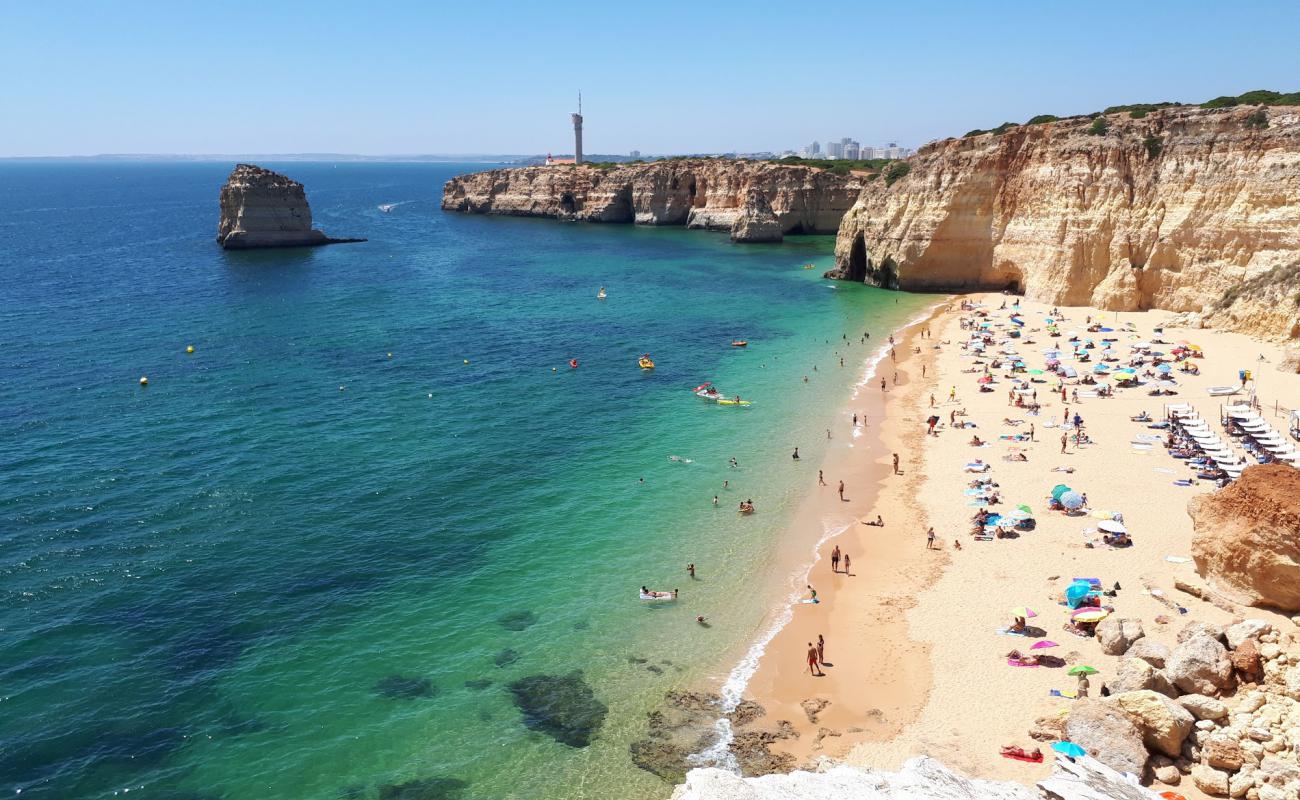 Фото Praia dos Caneiros с темный чистый песок поверхностью