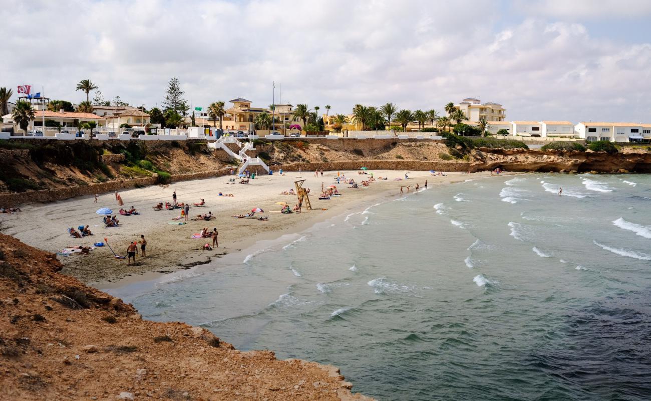 Фото Playa Cala Cerrada с темный песок поверхностью