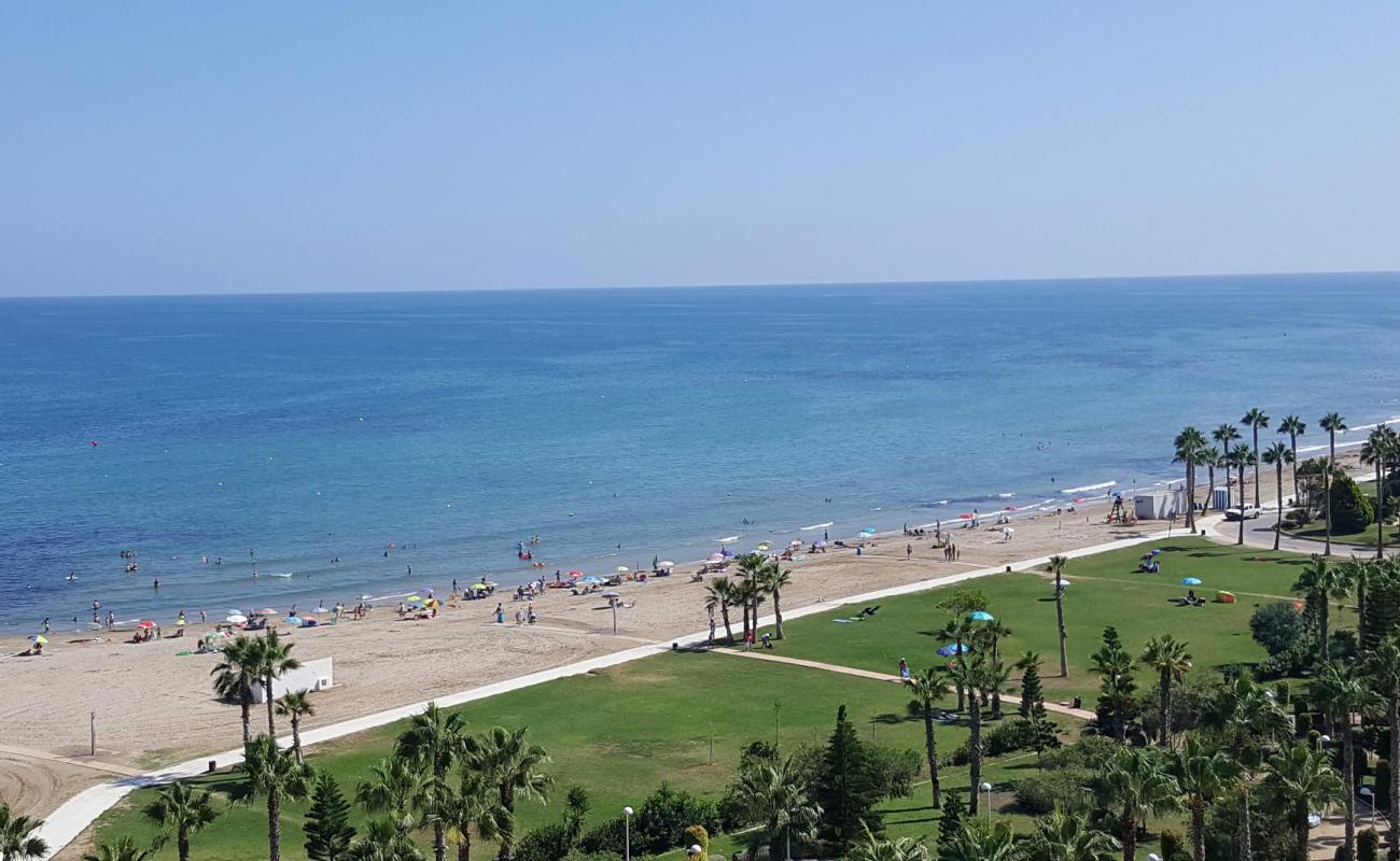 Фото Playa de les Amplaries с темный песок поверхностью