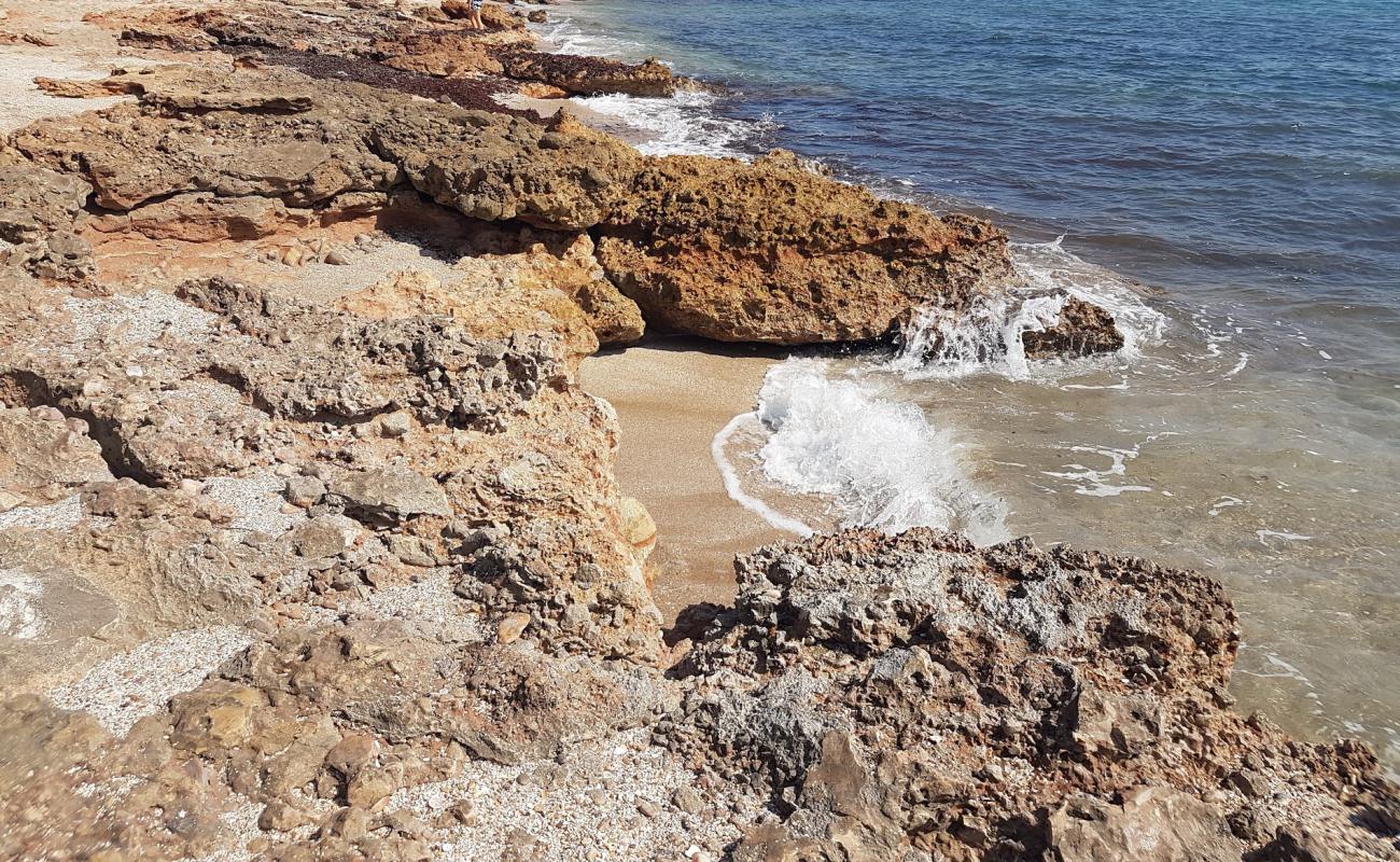 Фото Cala l'Arjub с песок с камнями поверхностью