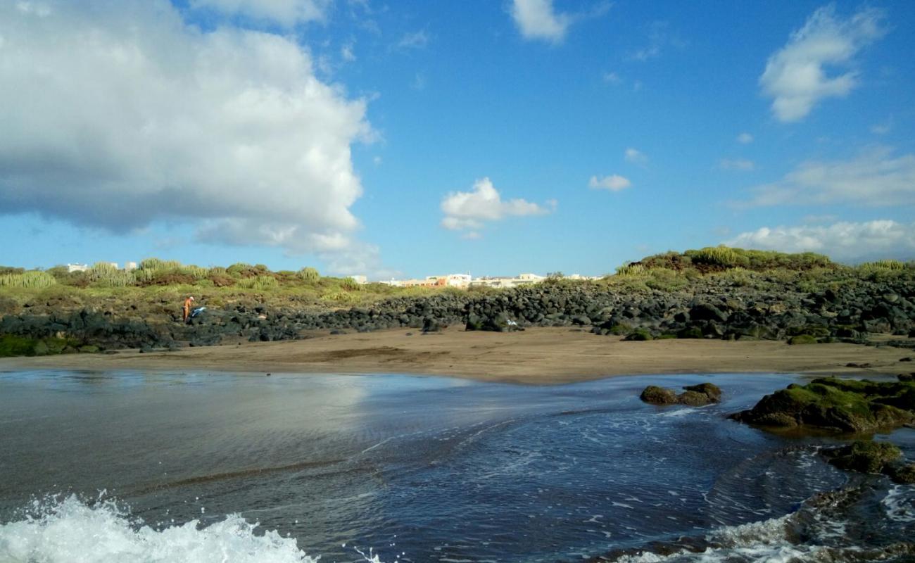 Фото Playa Los Enojados с темный песок поверхностью