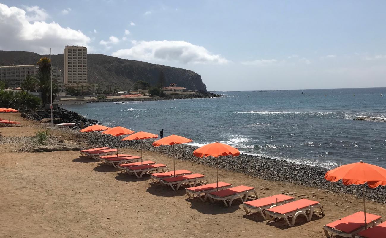 Фото Playa De Los Tarajales с песок с камнями поверхностью