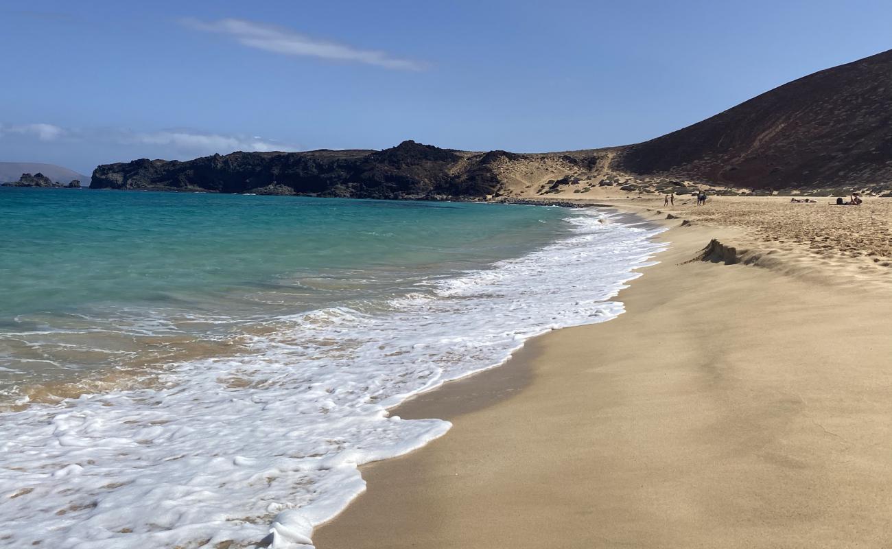 Фото Playa de las Conchas с золотистый песок поверхностью