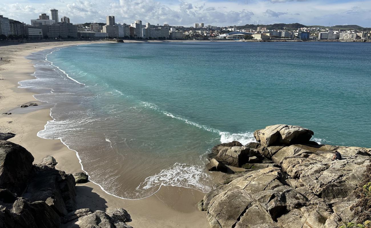 Фото Praia de Riazor с светлый песок поверхностью