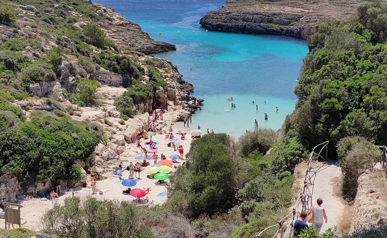 Фото Cala Binidali с светлый песок поверхностью