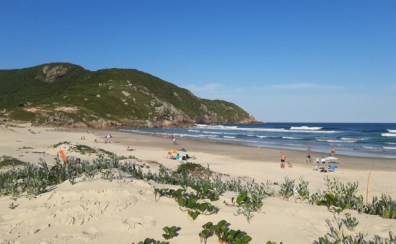 Фото Praia do Santinho с золотистый песок поверхностью