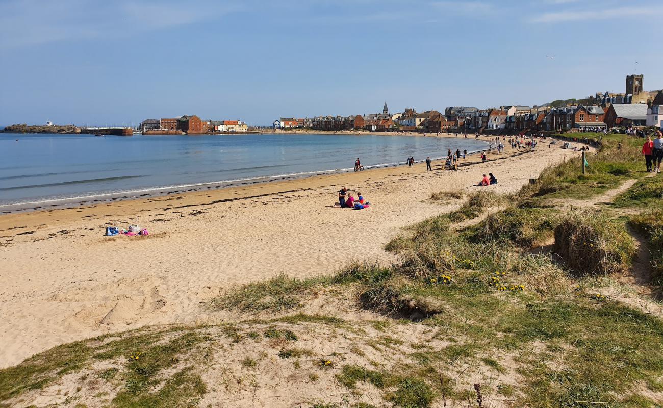 Фото West Bay Beach с светлый песок поверхностью